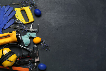 Construction tools with Easter eggs, rabbit and flowers on dark background