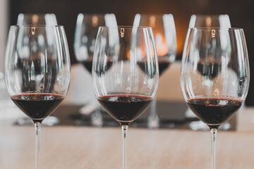 Red wine in glasses against a fireplace backdrop