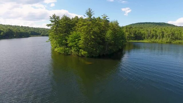 A spectacular 4K drone shot over Parker Pond and Pleasant Lake, located in Casco, Maine, USA. The camera moves low over the surface of the water, then rises and pans down over a forested peninsula.