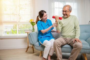 Asian nurse physiotherapist helping senior man in lifting dumbell at retirement home, Young nurse...