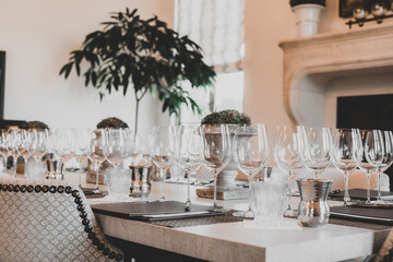 Wine glasses prepared for a wine tasting against a fireplace backdrop