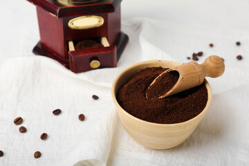 Bowl of coffee powder with scoop on white napkin, closeup