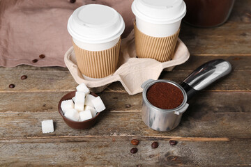 Scoop of coffee powder, sugar and cups on wooden table
