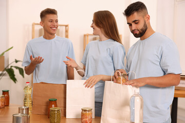 Group of volunteers packing food products indoors