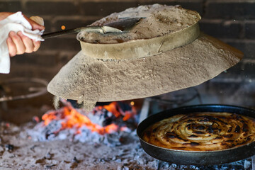 Capturing the essence of Bosnian culinary tradition, step-by-step preparation of a traditional Bosnian pie, showcasing the meticulous craftsmanship and authentic flavors involved in the culinary