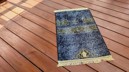 The gray prayer mat or sajadah for prayer or salat on the wooden floor gives a calming and solemn impression