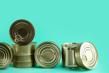 Tin cans with fish on turquoise background