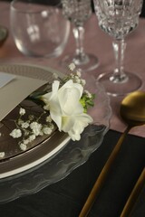 Stylish table setting with floral decor on black surface