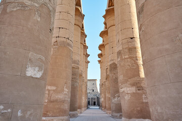 Majestic columns with ancient Egyptian drawings, sun comes out from behind the column. luxor Temple...