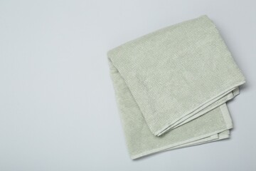 Soft green towel on light grey background, top view. Space for text