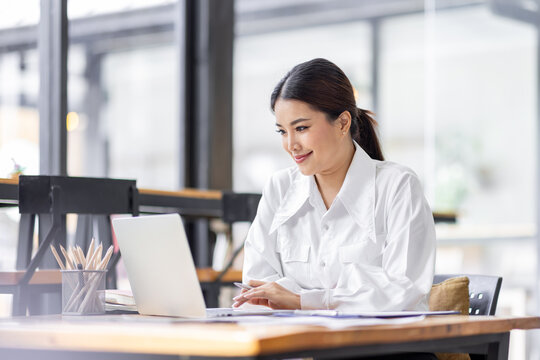 Asian Business woman work in the office. concept of tax, report, accounting, statistics, and analytical research.