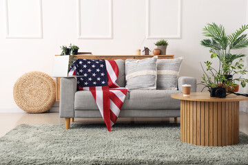 Sofa with USA flag and laptop in interior of living room
