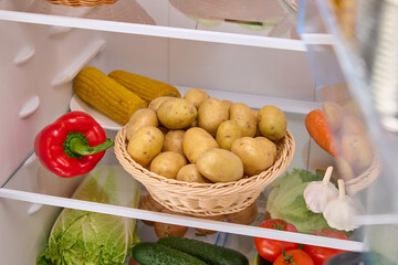 open refrigerator with organic potatoes basket 