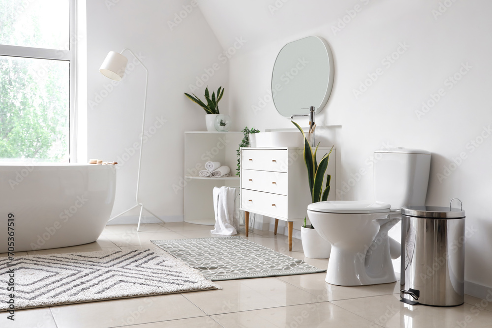 Canvas Prints Interior of light bathroom with bathtub, sink on chest of drawers and toilet bowl