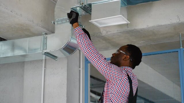 African hvac worker install ducted pipe system for ventilation and air conditioning