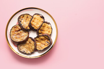 Plate with delicious grilled eggplants on pink background, top view