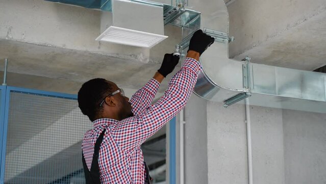Professional Black Heating and Cooling Technician Worker Finishing Newly Assembled Air Vent Shaft