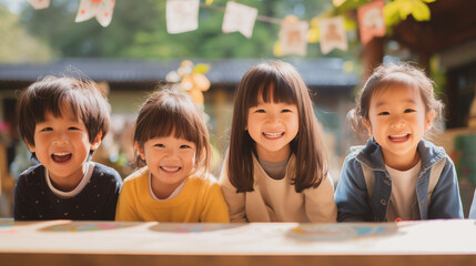 日本の幼稚園児・小学生4人が私服で横に並んで笑っている写真、背景自然の森とガーランド、森のようちえん - obrazy, fototapety, plakaty