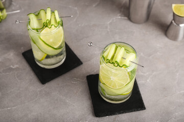 Glasses of mojito with cucumber on grunge grey table