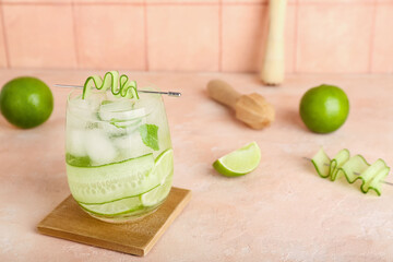 Glass of mojito with cucumber on pink grunge table