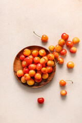 Plate with sweet yellow cherries on white background