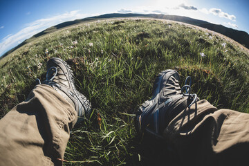 Hiker relaxing on summer high altitude flowering grassland