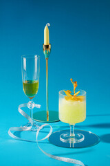 Delicious drinks with cups of cocktail and wine decorated on a blue background. Front view, scene for advertising product with holiday concept. Copy space