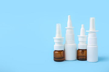 Bottles of nasal drops on blue background