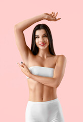 Young woman with shaved underarms on pink background
