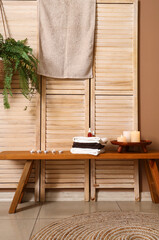 Burning candles with towels on table in spa salon