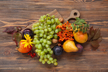 Board with different fresh fruits on wooden background