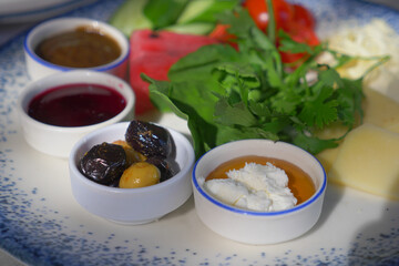 butter cream and honey in a bowl, olive and cheese on a plate 