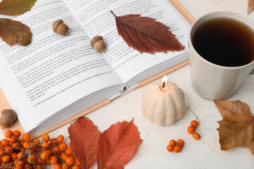Naklejka na ściany i meble Beautiful autumn composition with burning candle in shape of pumpkin and cup of tea on white background
