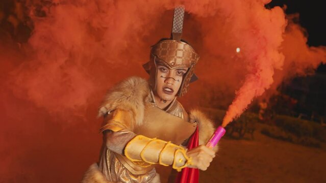 A soldier in golden armor prepares for battle as red smoke covers the battlefield in a palace