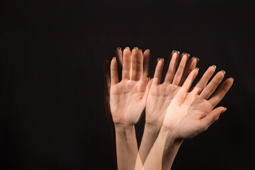 Stroboscopic photo of moving female hand on dark background
