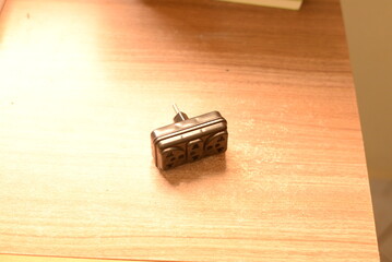 Adaptador de tomada preto em cima da mesa © LuanLeonel
