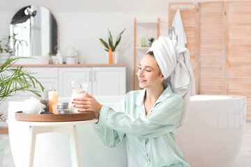 Beautiful woman after shower with jug of milk in bathroom
