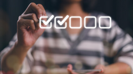Businesswomen use pens to tick the correct sign mark in the checkbox for the quality document control checklist and business approve project concept.
