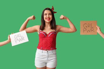 Beautiful young happy pin-up woman showing muscles and hands holding paper sheets with text GIRL...
