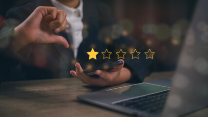 Businesswomen chose a 1-star rating review in the survey on the virtual touch screen on smartphones. Bad review, bad service dislike bad quality, low rating, social media not good - obrazy, fototapety, plakaty