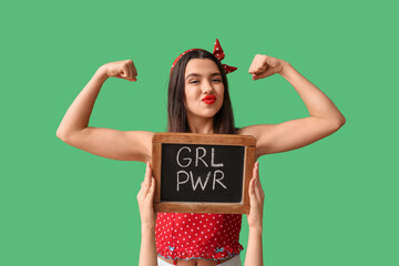 Beautiful young pin-up woman showing muscles and hands holding blackboard with text GIRL POWER on...
