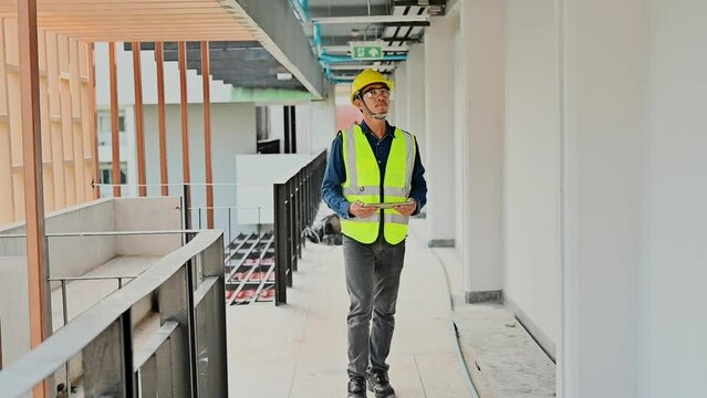 Construction Engineer uses tablets to check details of work and record data while inspecting construction work, Inspecting progress of work for planning and management.