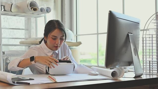 Architect young woman working with virtual reality technology modeling software applications in the office. Use augmented reality modeling in Building Information Model (BIM) tech system complete.