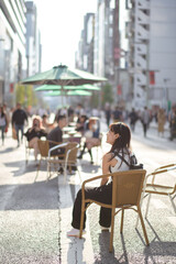 Experience urban joy in Tokyo, a happy asian woman enjoying city bench.