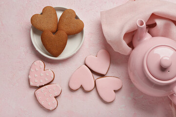 Teapot with tasty heart shaped cookies on pink grunge background. Valentine's Day celebration