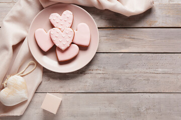 Plate with tasty heart shaped cookies, decor and gift box on grey wooden background. Valentine's...