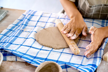 Kids making a craft of a porcelain mug from wet clay