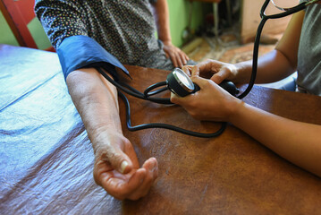 Elderly person taking their blood pressure at home. Concept of arterial hypertension.