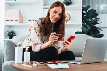 Young happy woman buy product by online shopping at home while ordering items from the internet...