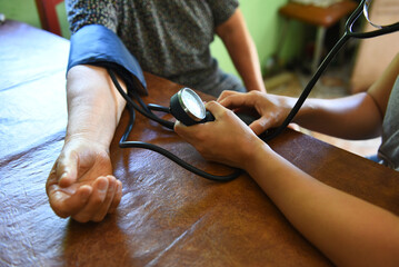 Elderly person taking their blood pressure at home. Concept of arterial hypotension.